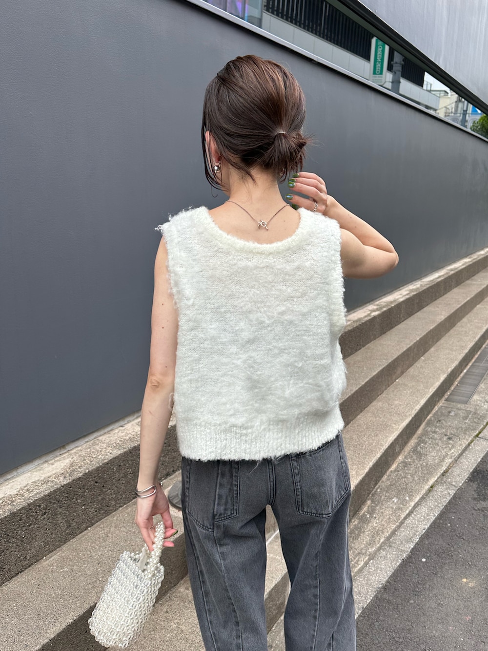 ホワイト系のカーディガン/ボレロ、ブラック系のキャミソール、ブルー系のデニムパンツを着用したレディースの夏コーディネートの3枚目の写真