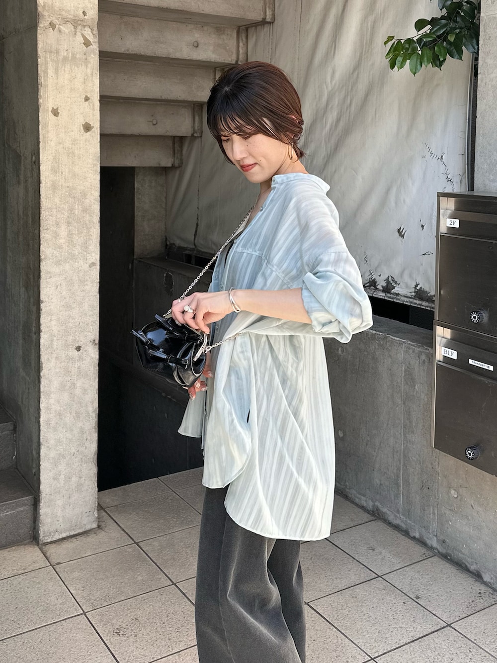 グリーン系のシャツ/ブラウス、ブラック系のデニムパンツ、ブラック系のショルダーバッグを着用したレディースの夏コーディネートの4枚目の写真