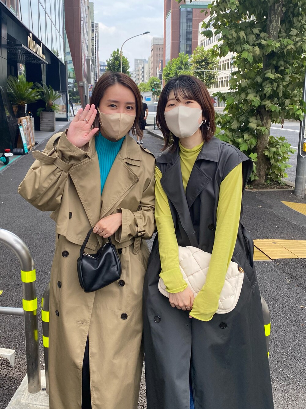 グレー系のトレンチコート、グリーン系のTシャツ/カットソー、ホワイト系のショルダーバッグを着用したレディースの夏コーディネートの5枚目の写真