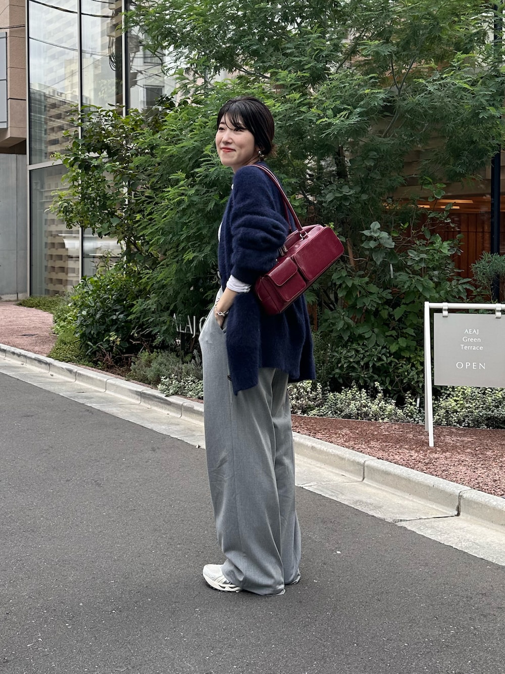 ブルー系のカーディガン/ボレロ、ホワイト系のTシャツ/カットソー、ブラック系のバッグを着用したレディースの秋コーディネートの3枚目の写真