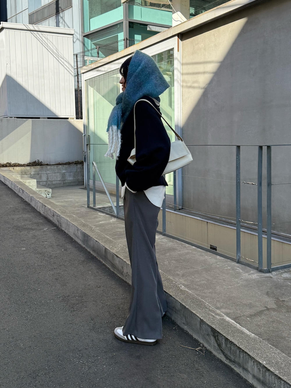 ブルー系のニット/セーター、グレー系のその他パンツ、ホワイト系のTシャツ/カットソーを着用したレディースの冬コーディネートの2枚目の写真