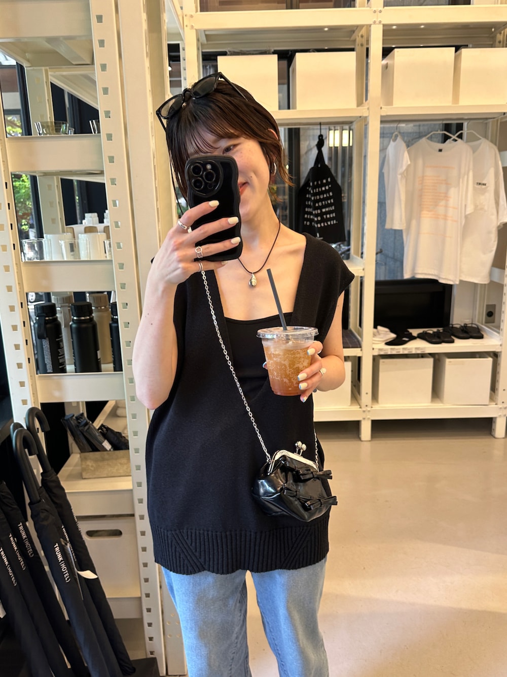 ブラック系のニット/セーター、ブルー系のデニムパンツ、ブラック系のシューズを着用したレディースの春コーディネートの4枚目の写真