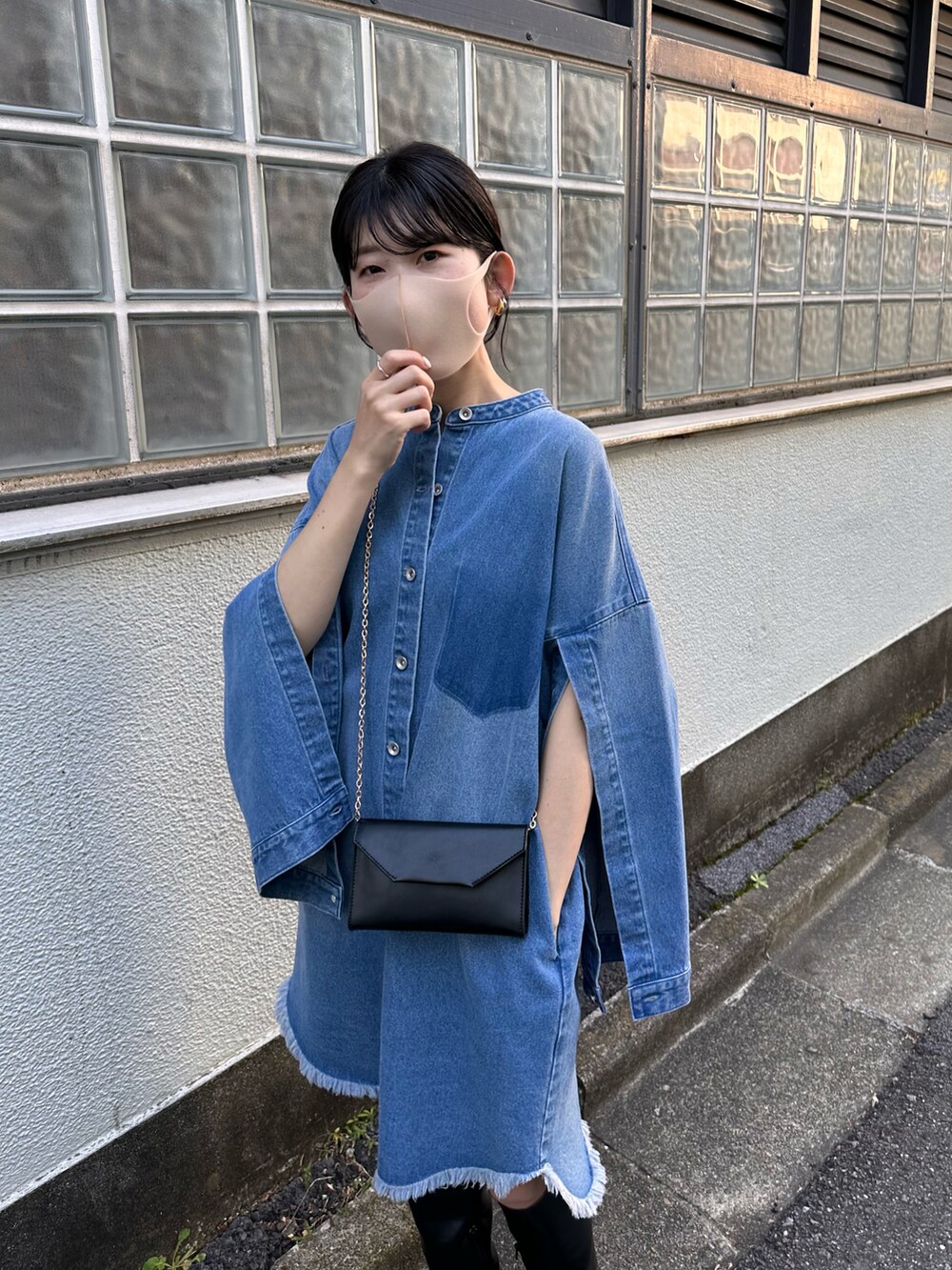 ブラック系のショルダーバッグ、ブルー系のシャツワンピースを着用したレディースの秋コーディネートの2枚目の写真
