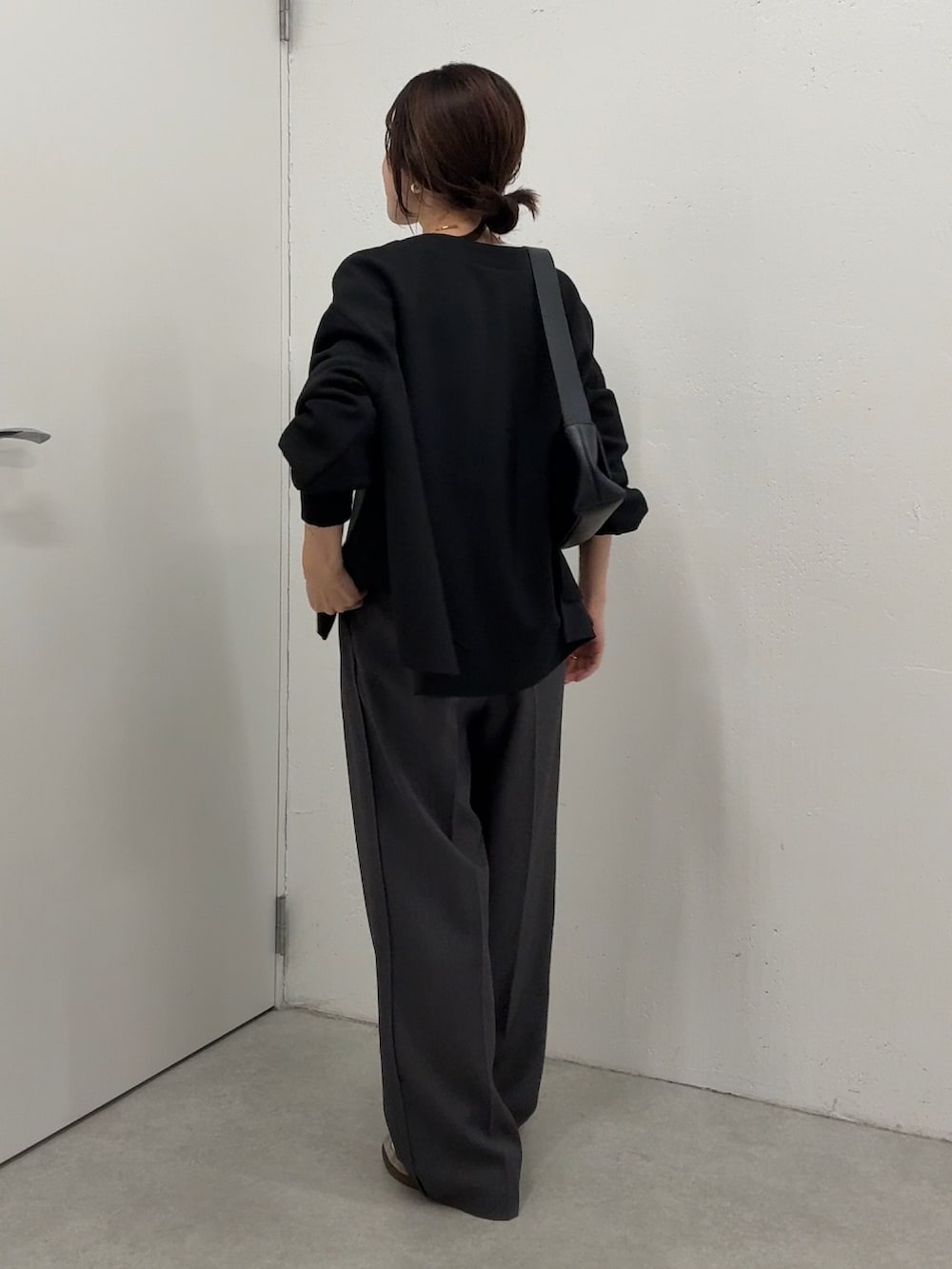 ブラック系のカーディガン/ボレロ、ホワイト系のTシャツ/カットソー、グレー系のスラックスを着用したレディースの秋コーディネートの3枚目の写真