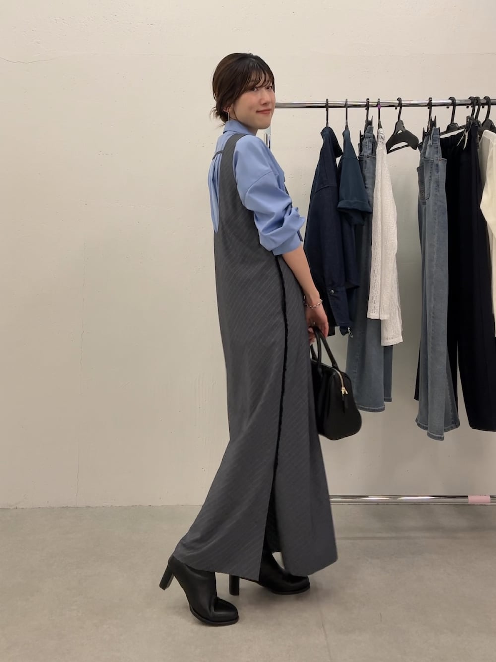 グレー系のワンピース、ブルー系のシャツ/ブラウス、ブラック系のボストンバッグを着用したレディースの秋コーディネートの3枚目の写真