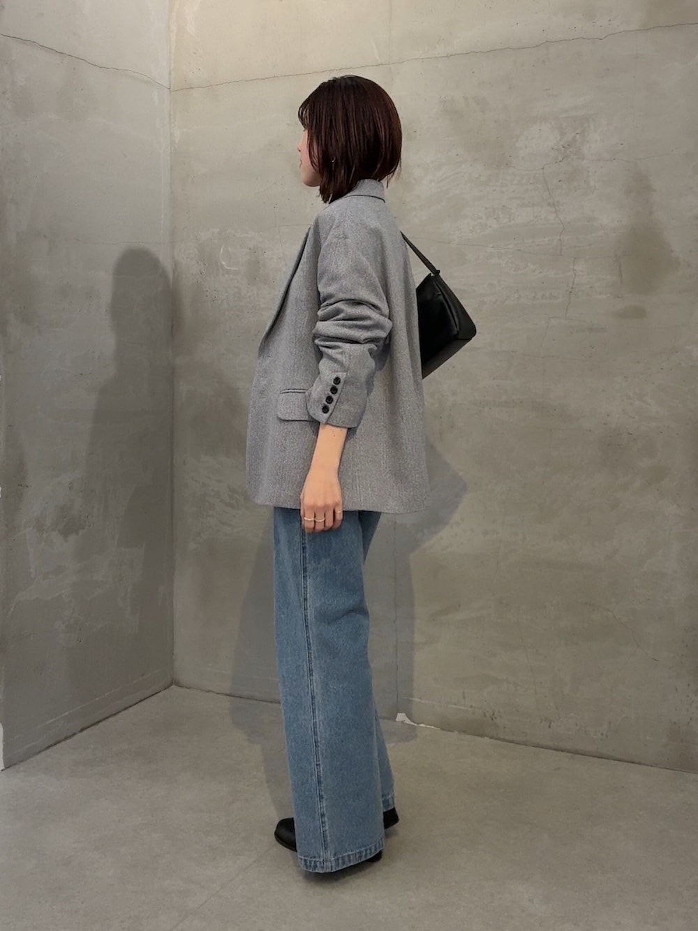 グレー系のテーラードジャケット、ブラック系のTシャツ/カットソー、ブルー系のサロペット/オーバーオールを着用したレディースの冬コーディネートの3枚目の写真