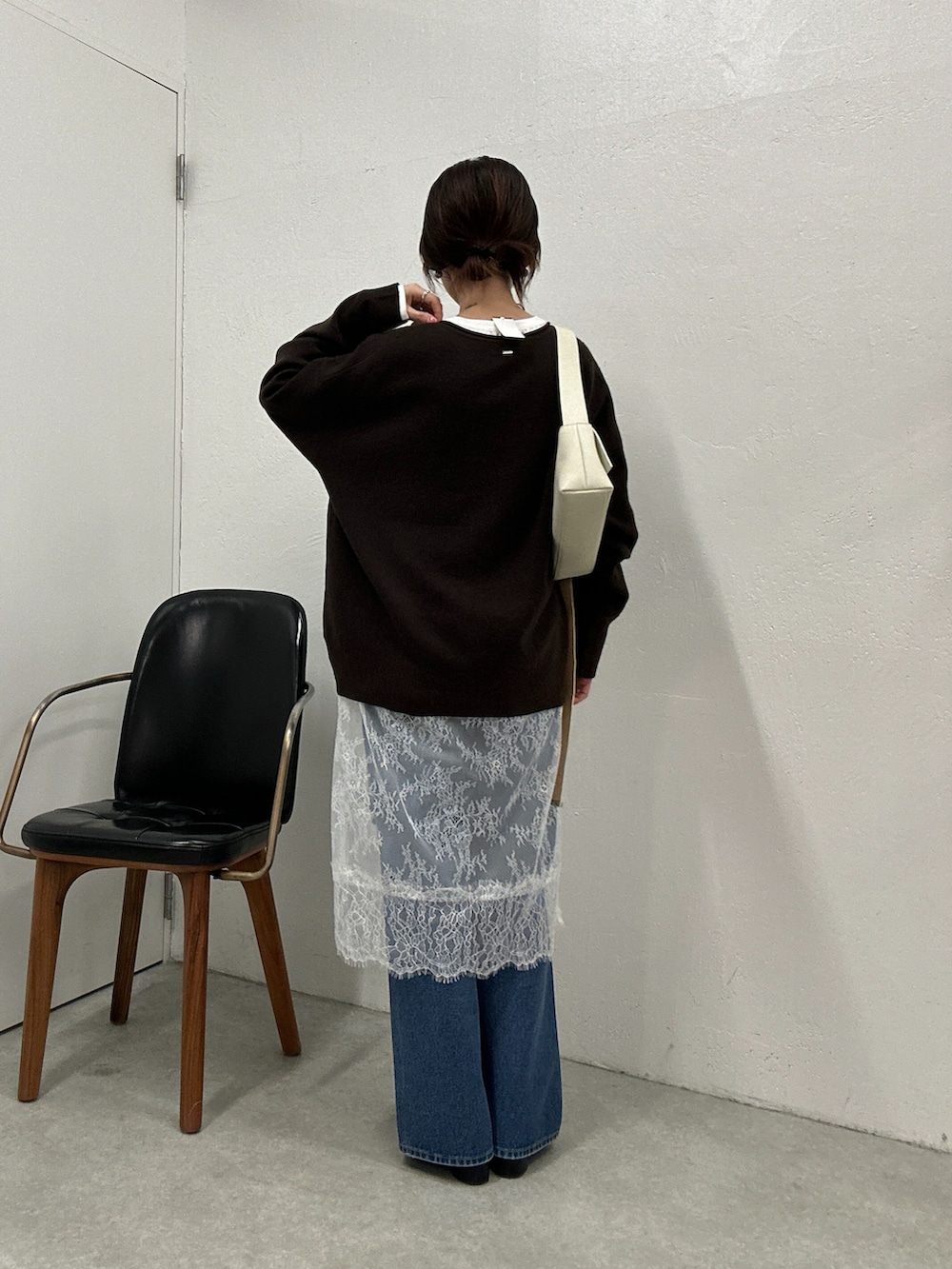 ブラウン系のニット/セーター、ホワイト系のチュニック、ブルー系のデニムパンツを着用したレディースの冬コーディネートの3枚目の写真