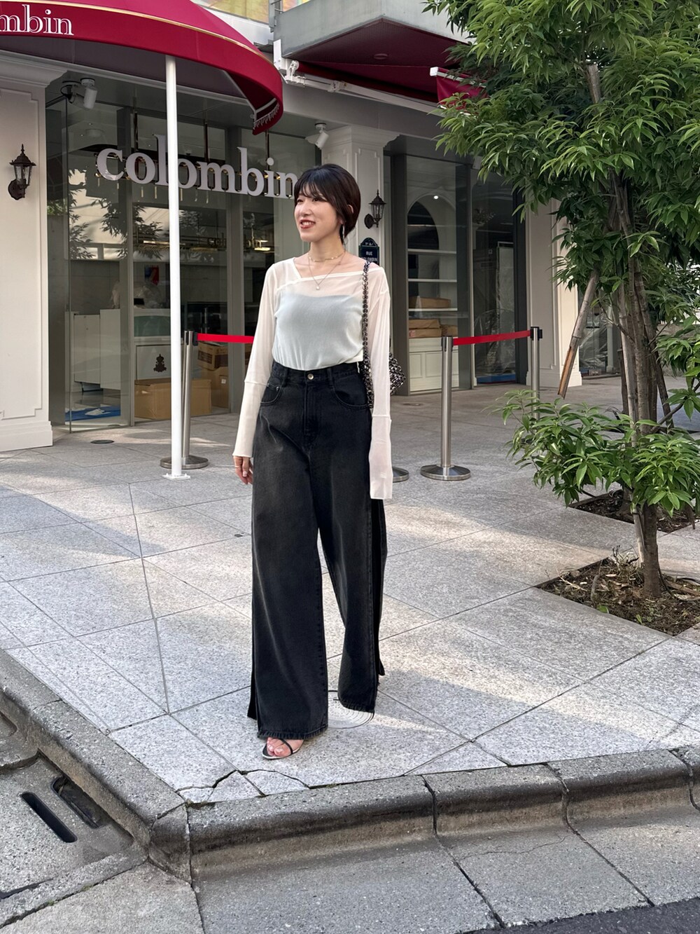 ホワイト系のTシャツ/カットソー、ブラック系のデニムパンツ、ブラック系のバッグを着用したレディースの夏コーディネートの3枚目の写真