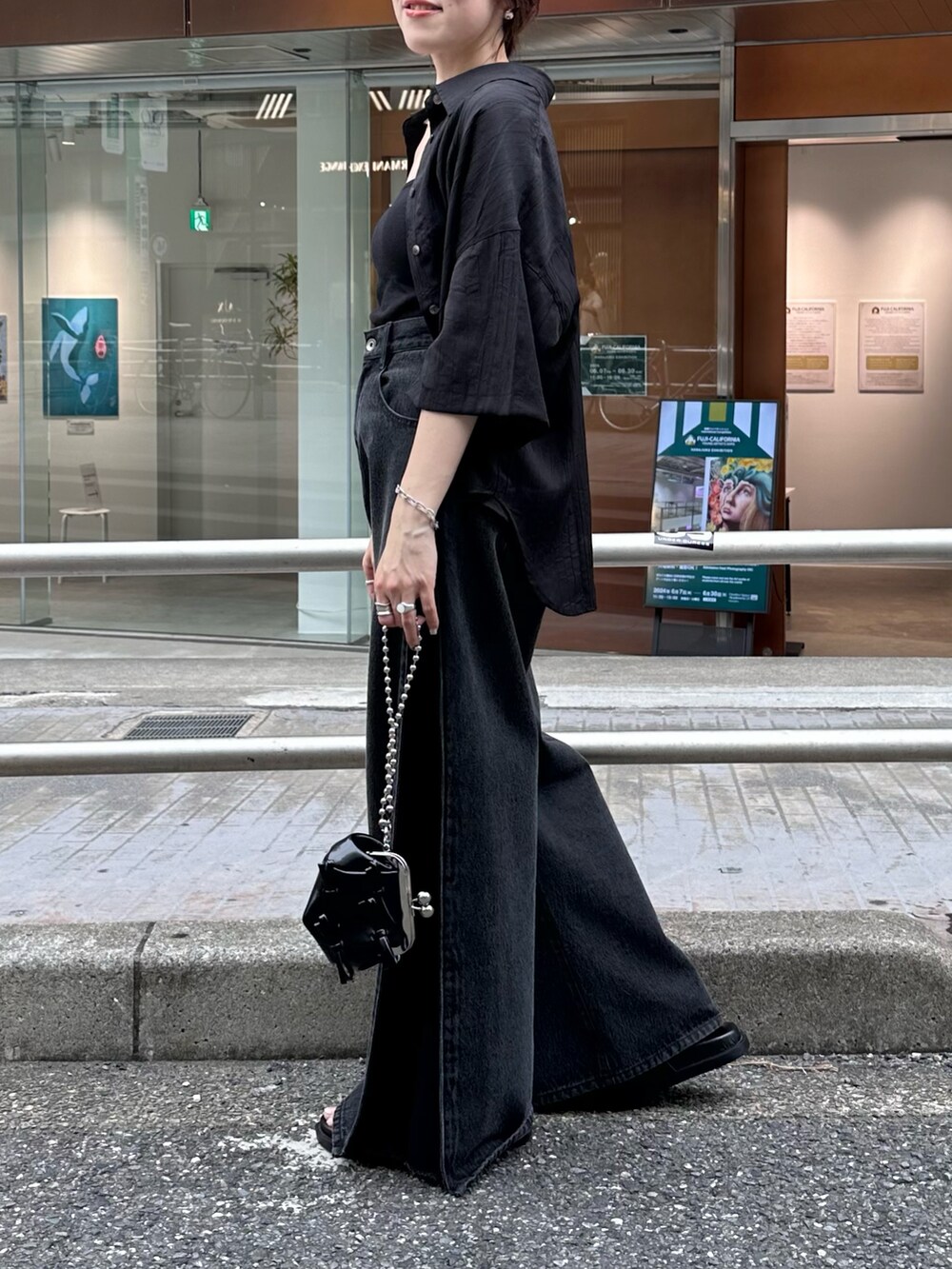 ブラック系のデニムパンツ、ブラック系のシャツ/ブラウス、ブラック系のショルダーバッグを着用したレディースの夏コーディネートの3枚目の写真