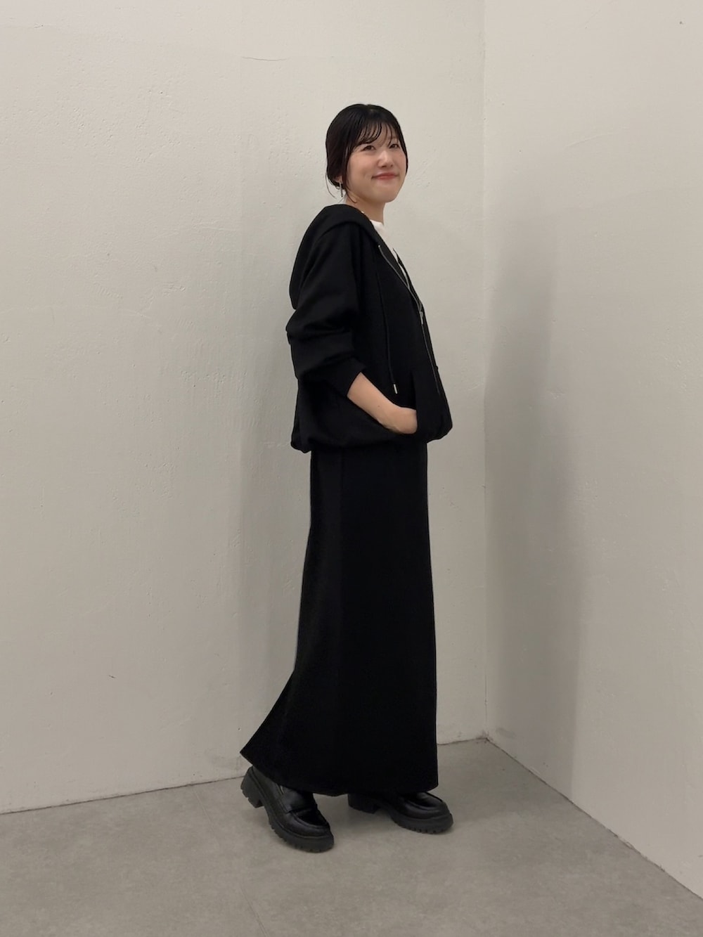 ブラック系のスカート、ブラック系のパーカーを着用したレディースの冬コーディネートの2枚目の写真