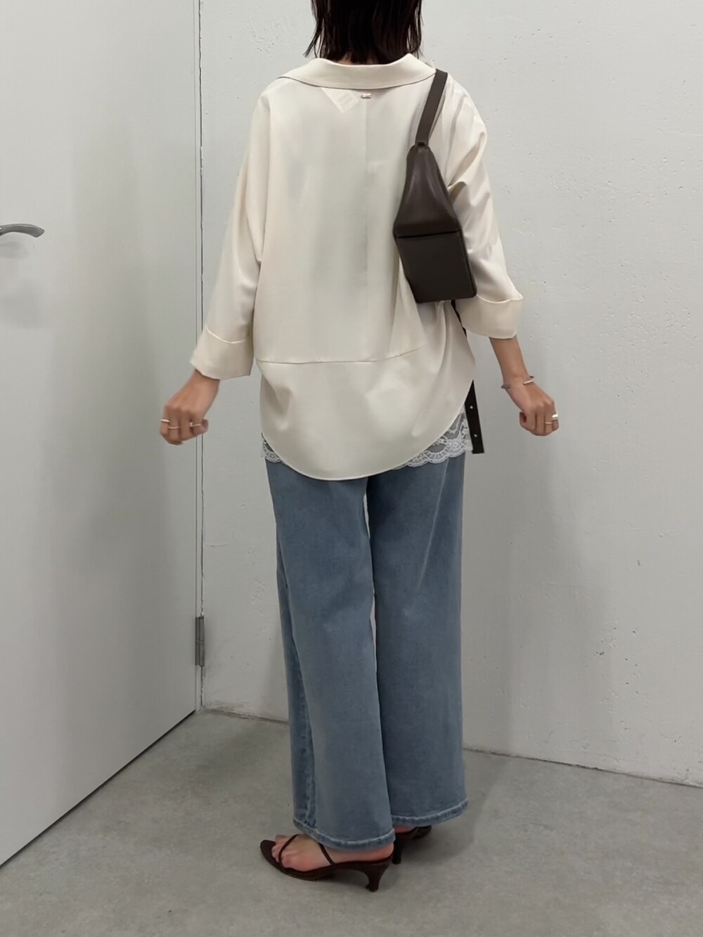 ホワイト系のシャツ/ブラウス、ホワイト系のキャミソール、ブルー系のデニムパンツを着用したレディースの春コーディネートの3枚目の写真