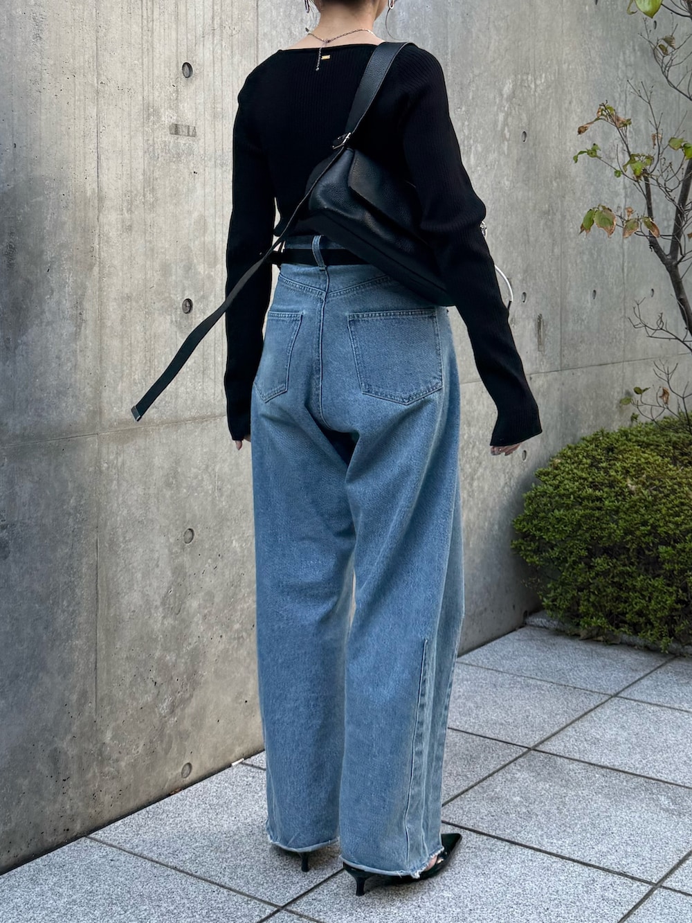 ブルー系のデニムパンツ、ブラック系のニット/セーター、ブラック系のパンプスを着用したレディースの秋コーディネートの4枚目の写真
