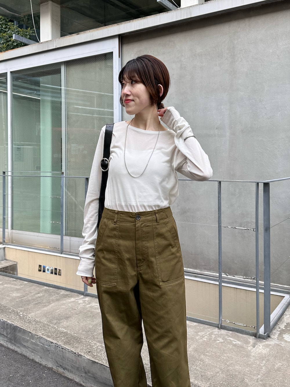 ホワイト系のTシャツ/カットソー、グリーン系のカーゴパンツ、ブラック系のバッグを着用したレディースの春コーディネートの4枚目の写真