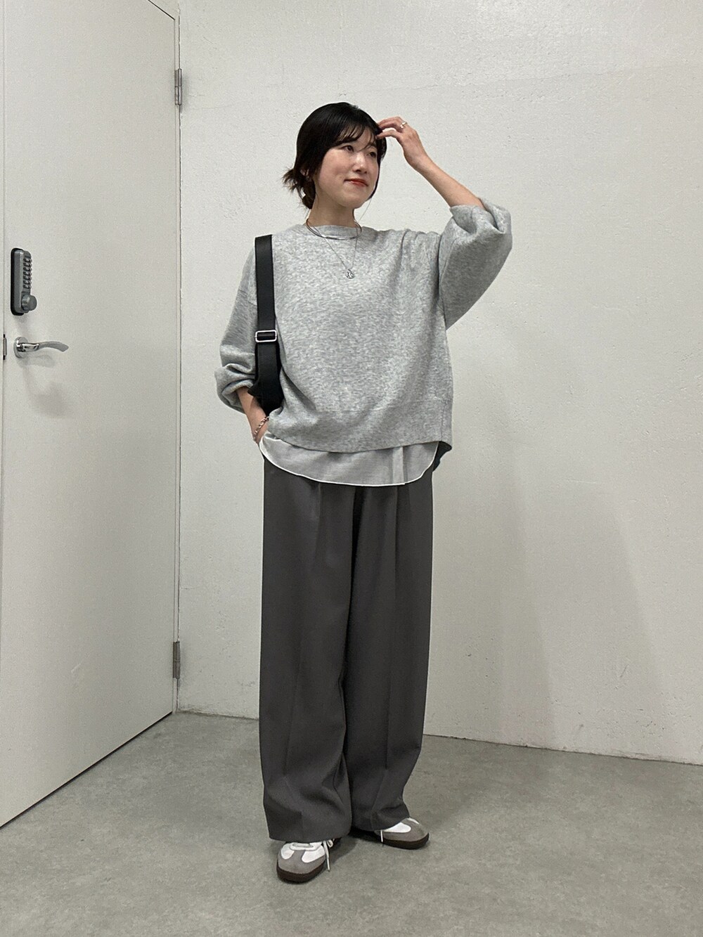 グレー系のニット/セーター、ホワイト系のTシャツ/カットソー、グレー系のその他パンツを着用したレディースの冬コーディネートの2枚目の写真