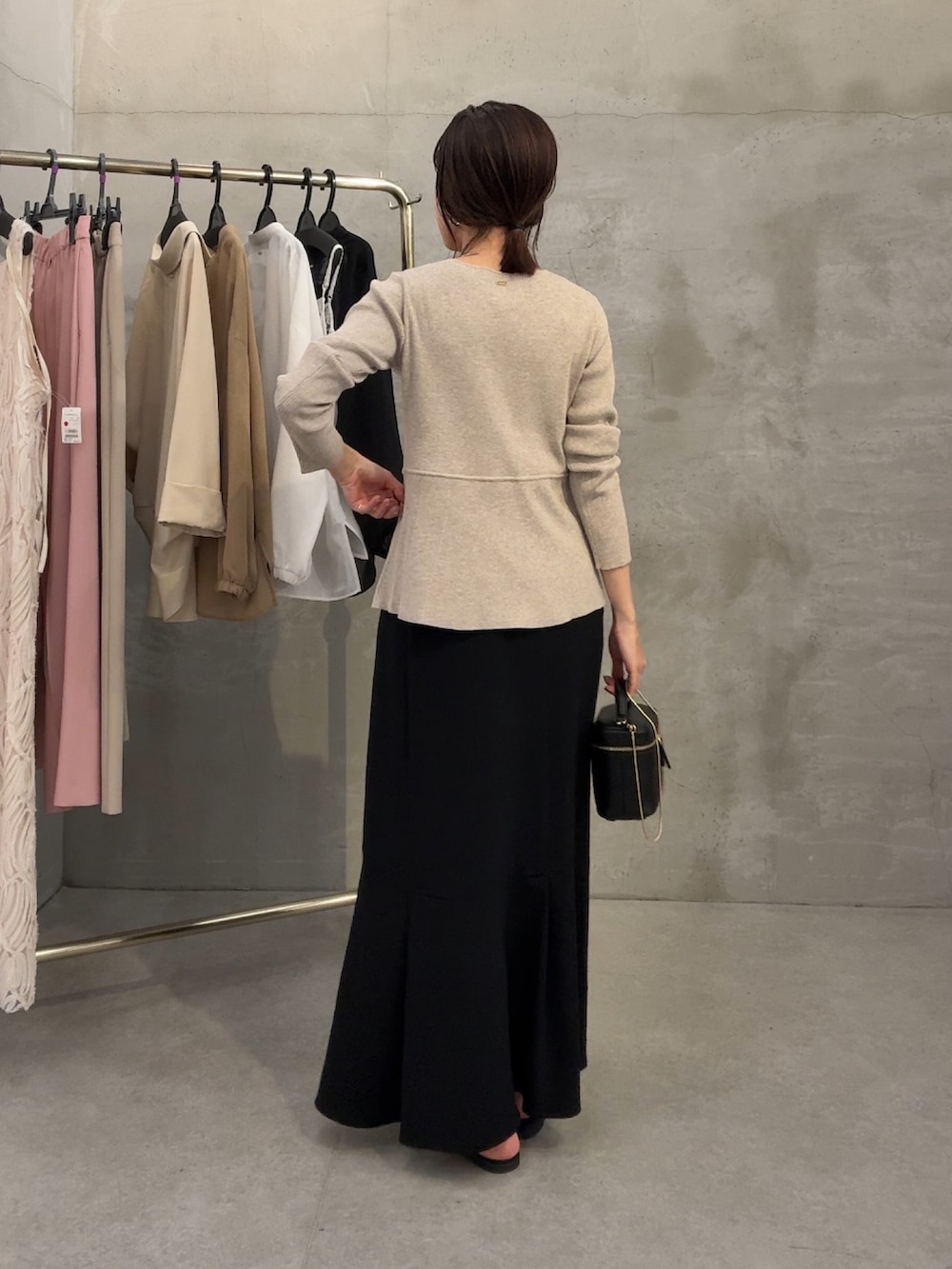 ベージュ系のカーディガン/ボレロ、ブラック系のスカート、ブラック系のショルダーバッグを着用したレディースの春コーディネートの3枚目の写真