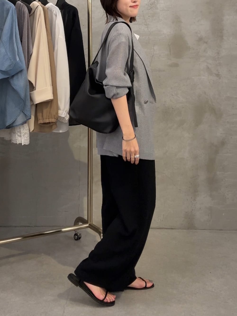 グレー系のテーラードジャケット、ホワイト系のTシャツ/カットソー、ブラック系のスラックスを着用したレディースの春コーディネートの3枚目の写真