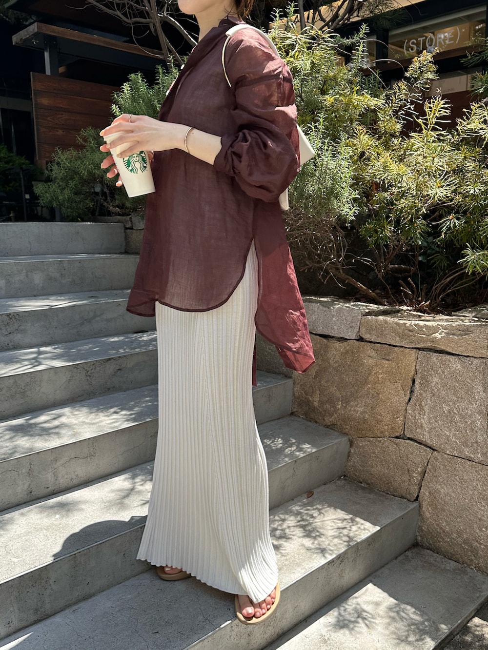 ブラウン系のシャツ/ブラウス、ホワイト系のワンピースを着用したレディースの春コーディネートの3枚目の写真