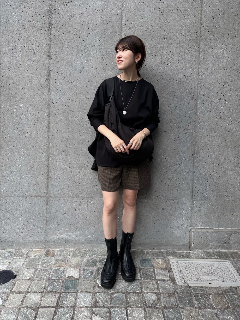 ブラック系のボディバッグ/ウエストポーチ、ブラック系のTシャツ/カットソー、ブラウン系のその他パンツを着用したレディースの秋コーディネートの3枚目の写真