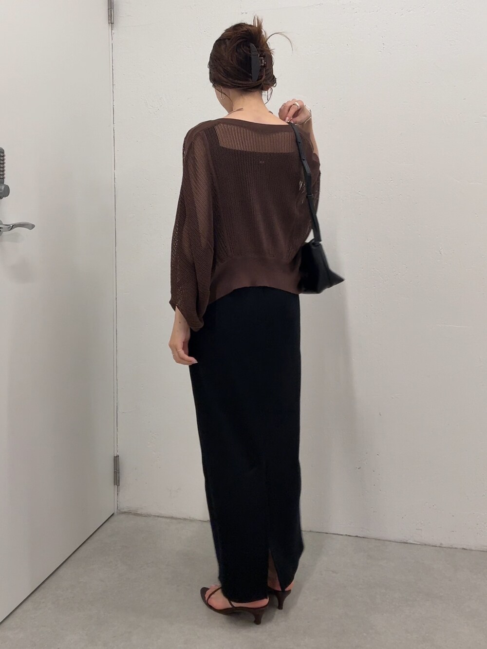 ブラック系のワンピース、ブラウン系のカーディガン/ボレロ、ゴールド系のネックレスを着用したレディースの夏コーディネートの2枚目の写真