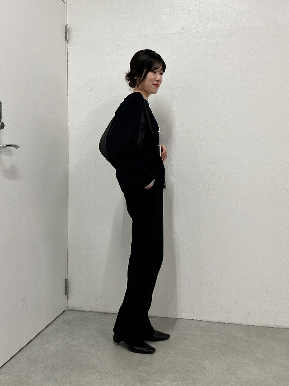 ホワイト系のTシャツ/カットソー、グレー系のニット/セーター、ブラック系のその他パンツを着用したレディースの秋コーディネートの4枚目の写真