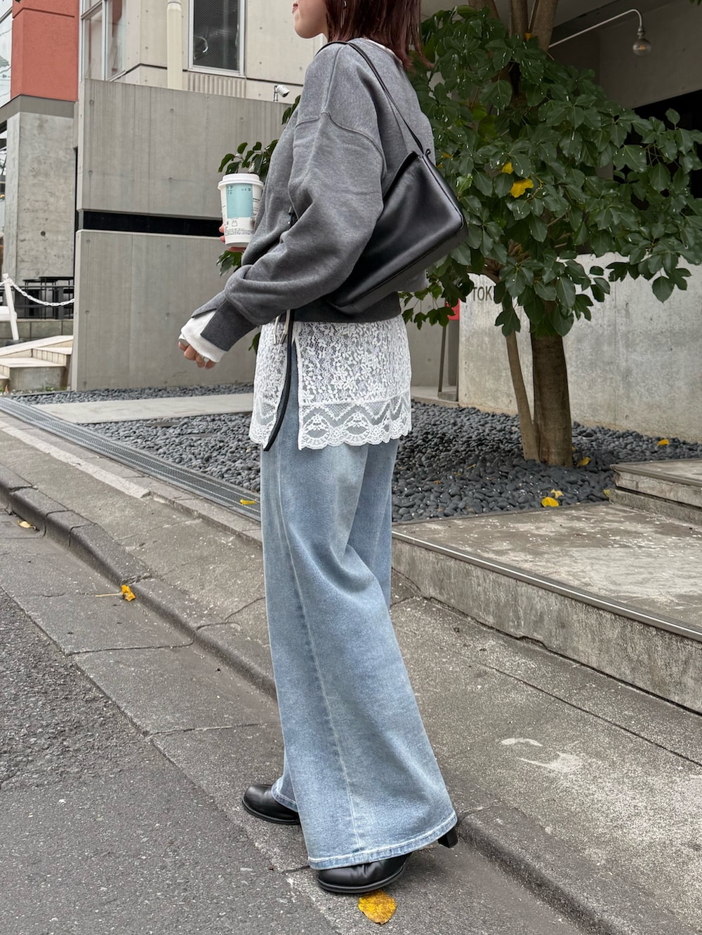 グレー系のスウェット、ホワイト系のキャミソール、ブラック系のショルダーバッグを着用したレディースの冬コーディネートの3枚目の写真