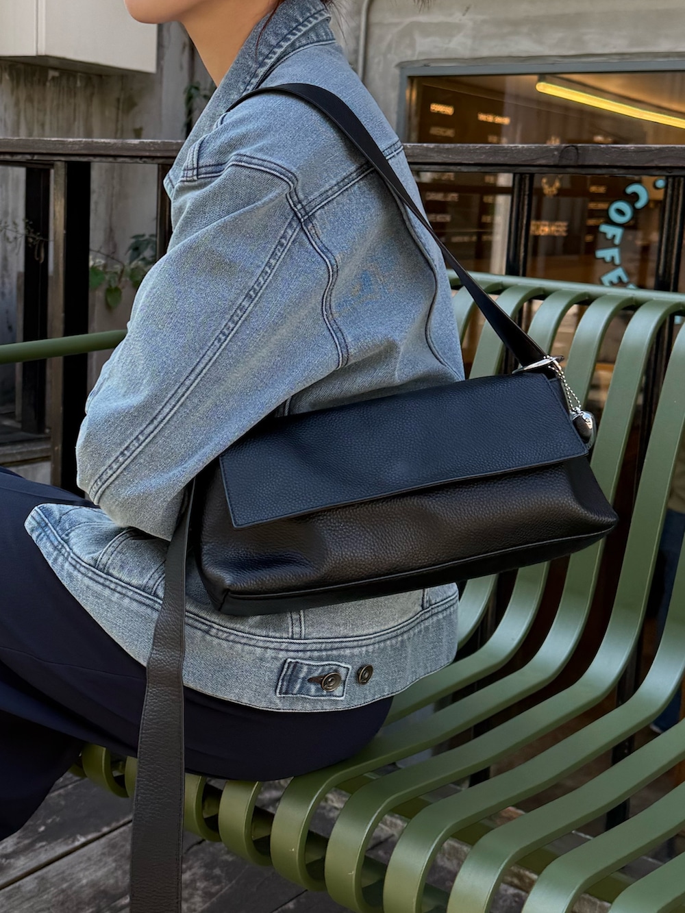 ブルー系のデニムジャケット、ブルー系のその他パンツ、ブラック系のショルダーバッグを着用したレディースの冬コーディネートの2枚目の写真