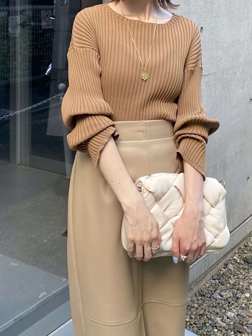 ホワイト系のショルダーバッグ、ベージュ系のスカートを着用したレディースの秋コーディネートの3枚目の写真