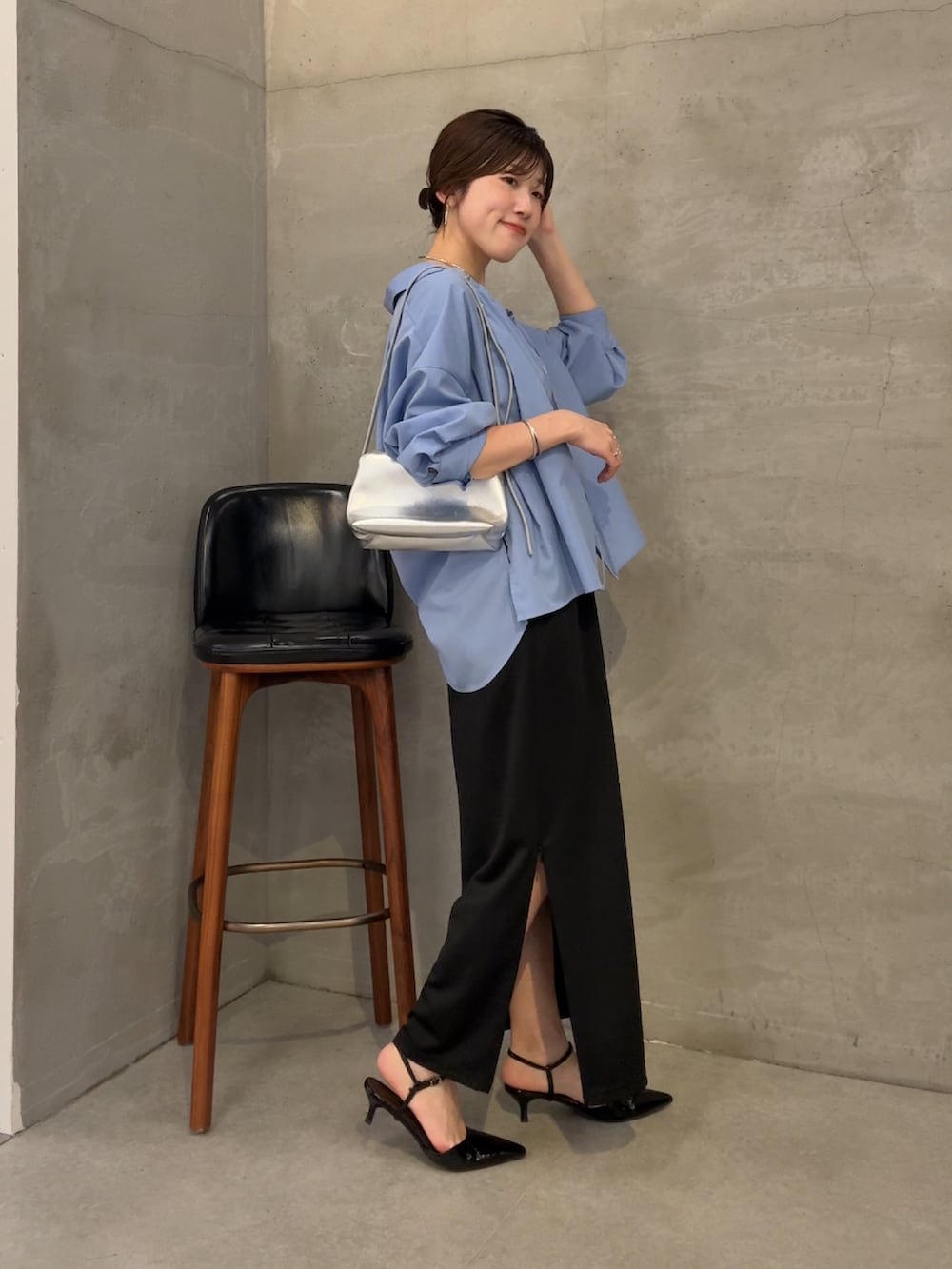 ブラック系のスカート、ブルー系のシャツ/ブラウス、シルバー系のショルダーバッグを着用したレディースの夏コーディネートの4枚目の写真