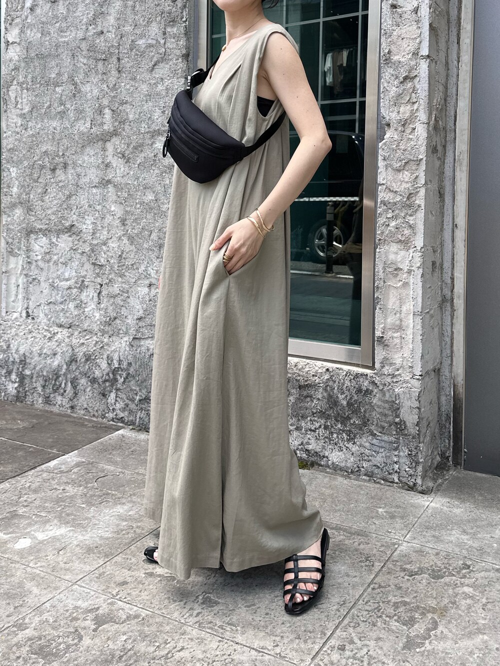 ブラック系のボディバッグ/ウエストポーチ、ブラック系のサンダル、ベージュ系のつなぎ/オールインワンを着用したレディースの春コーディネートの2枚目の写真