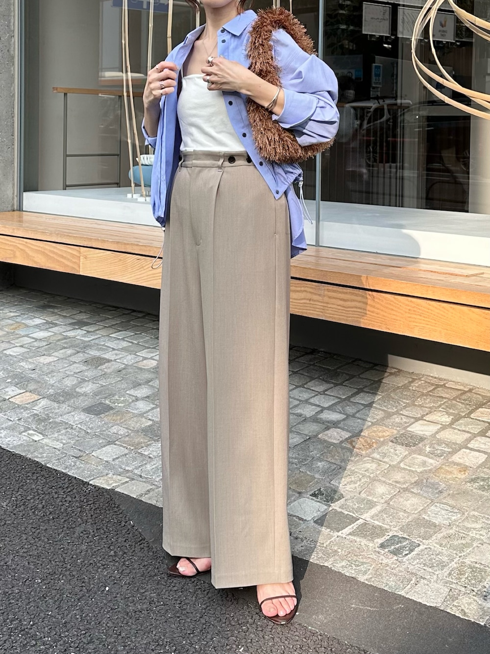 ブルー系のシャツ/ブラウス、ブラウン系のバッグ、ベージュ系のその他パンツを着用したレディースの夏コーディネートの2枚目の写真