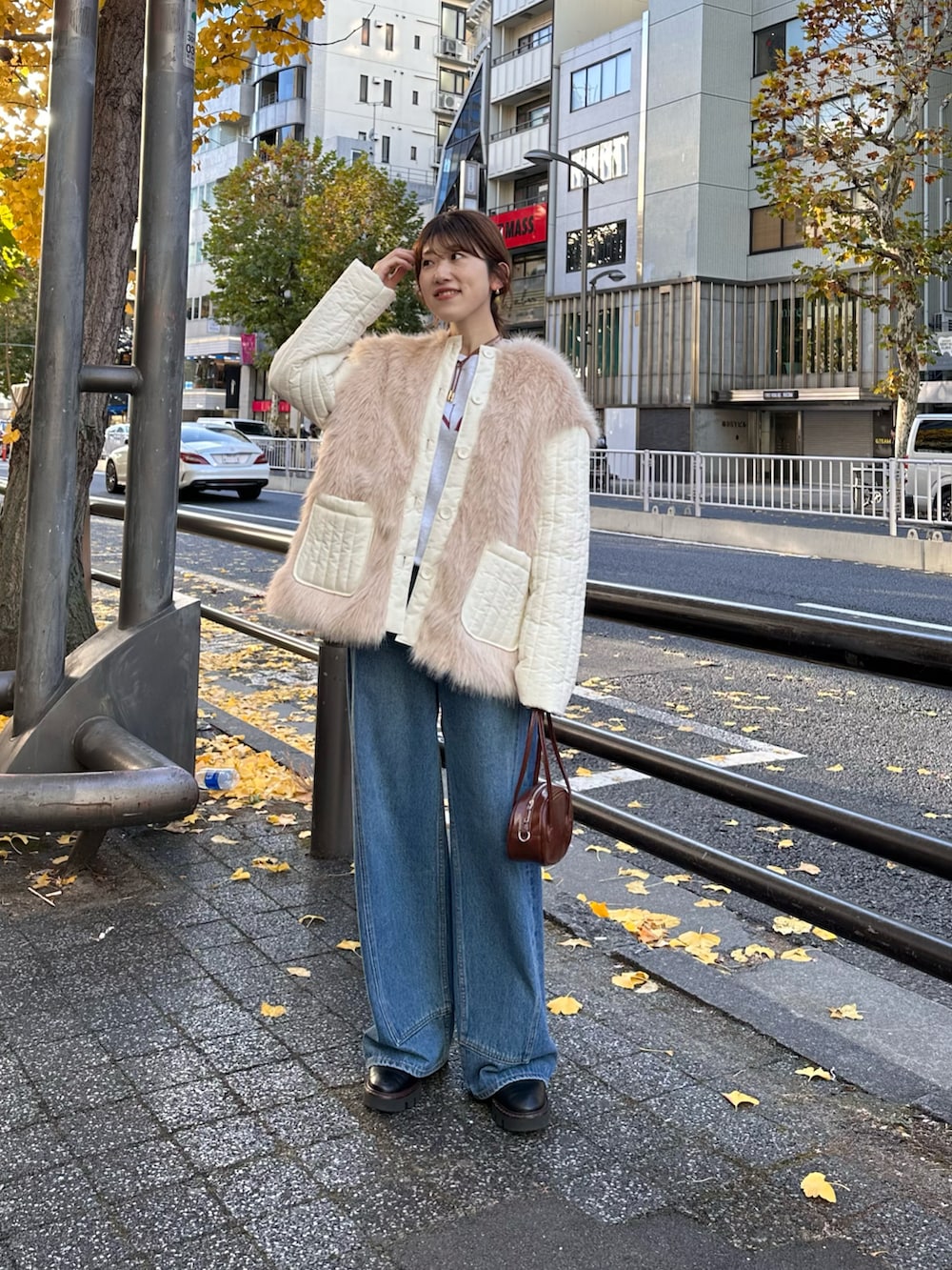 ブラウン系のハンドバッグ、ホワイト系のダウンジャケット/コート、グレー系のスウェットを着用したレディースの冬コーディネートの4枚目の写真