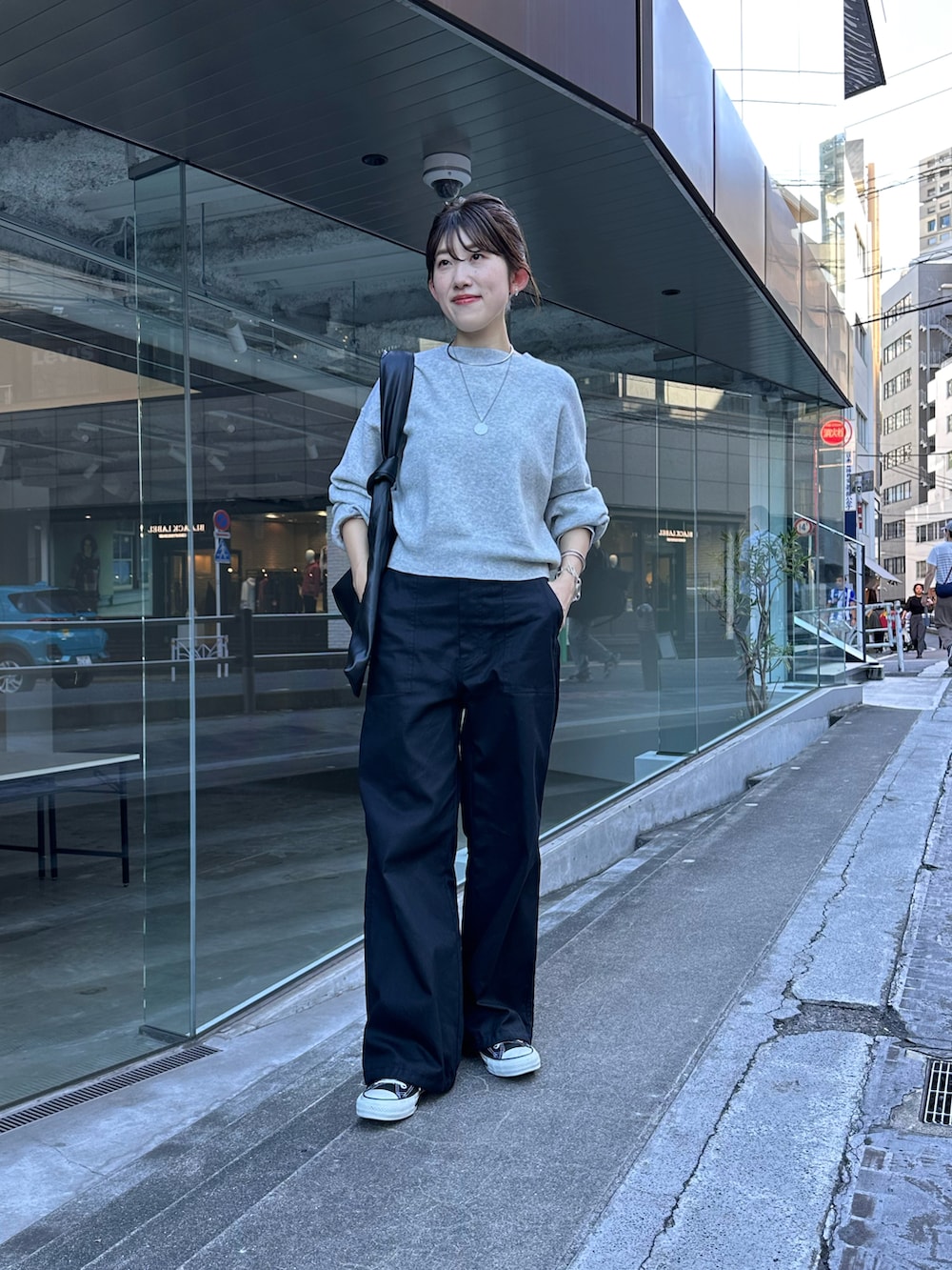 グレー系のニット/セーター、ブラック系のカーゴパンツ、シルバー系のネックレスを着用したレディースの秋コーディネートの4枚目の写真