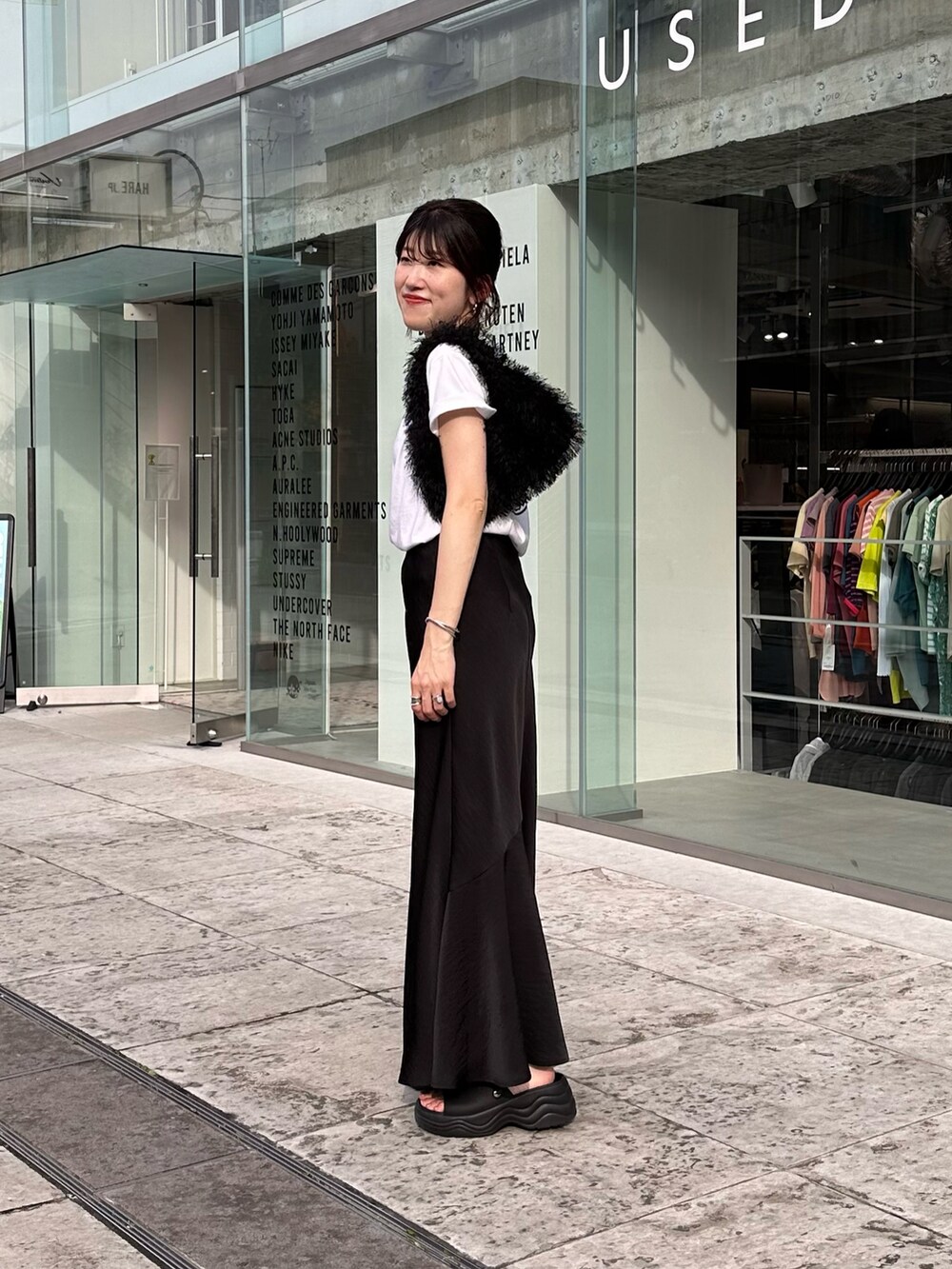 ホワイト系のTシャツ/カットソー、ブラック系のバッグ、ブラック系のスカートを着用したレディースの夏コーディネートの4枚目の写真