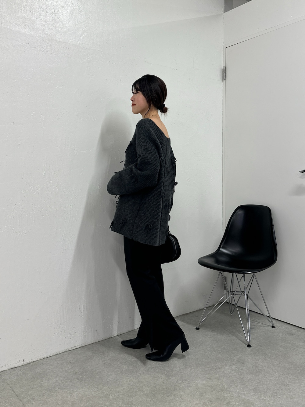 グレー系のニット/セーター、ブラック系のその他パンツ、ブラック系のハンドバッグを着用したレディースの秋コーディネートの3枚目の写真