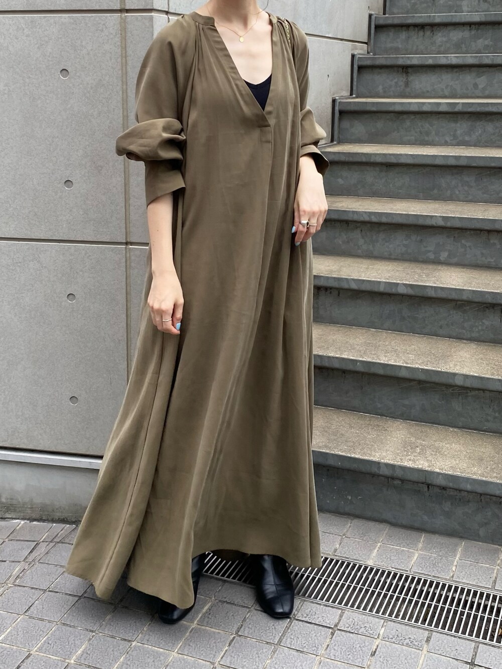 グリーン系のワンピース、ブラック系のブーツ、ブラック系のトートバッグを着用したレディースの夏コーディネートの4枚目の写真