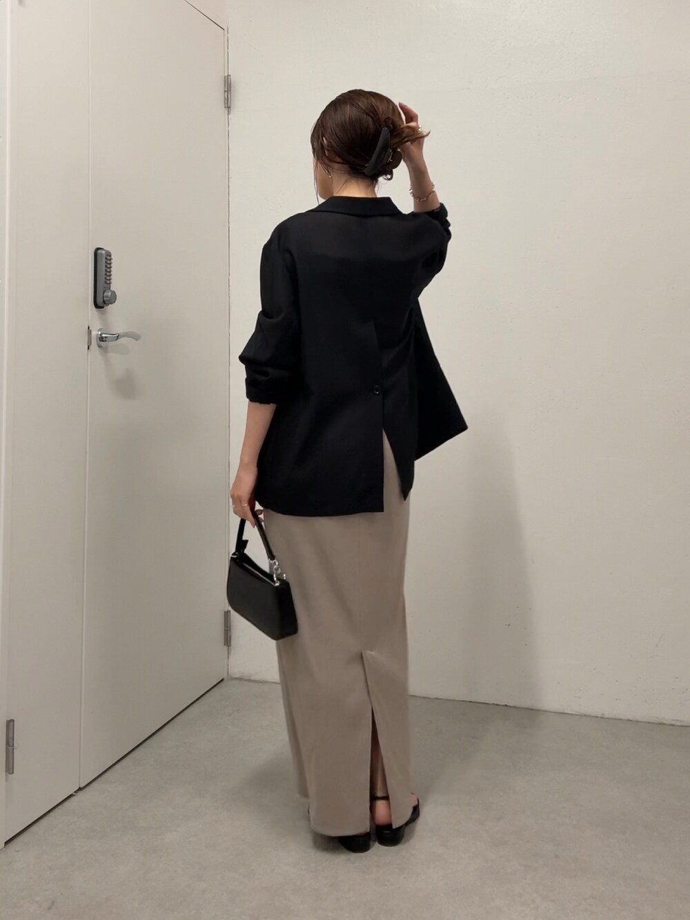 ベージュ系のワンピース、ブラック系のテーラードジャケット、ホワイト系のショルダーバッグを着用したレディースの夏コーディネートの3枚目の写真