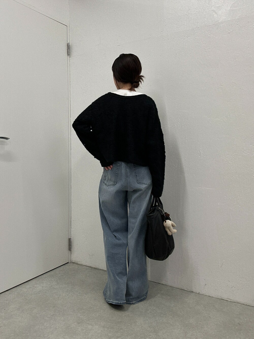 ブルー系のデニムパンツ、ブラック系のカーディガン/ボレロ、ホワイト系のシャツ/ブラウスを着用したレディースの秋コーディネートの2枚目の写真