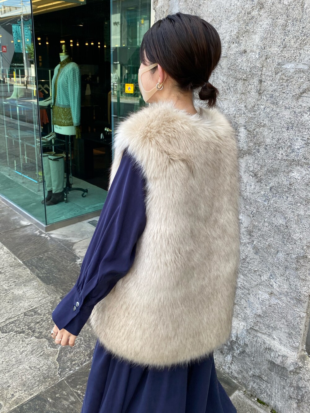 ブルー系のワンピース、ベージュ系のベスト、ブラック系のショルダーバッグを着用したレディースの秋コーディネートの5枚目の写真