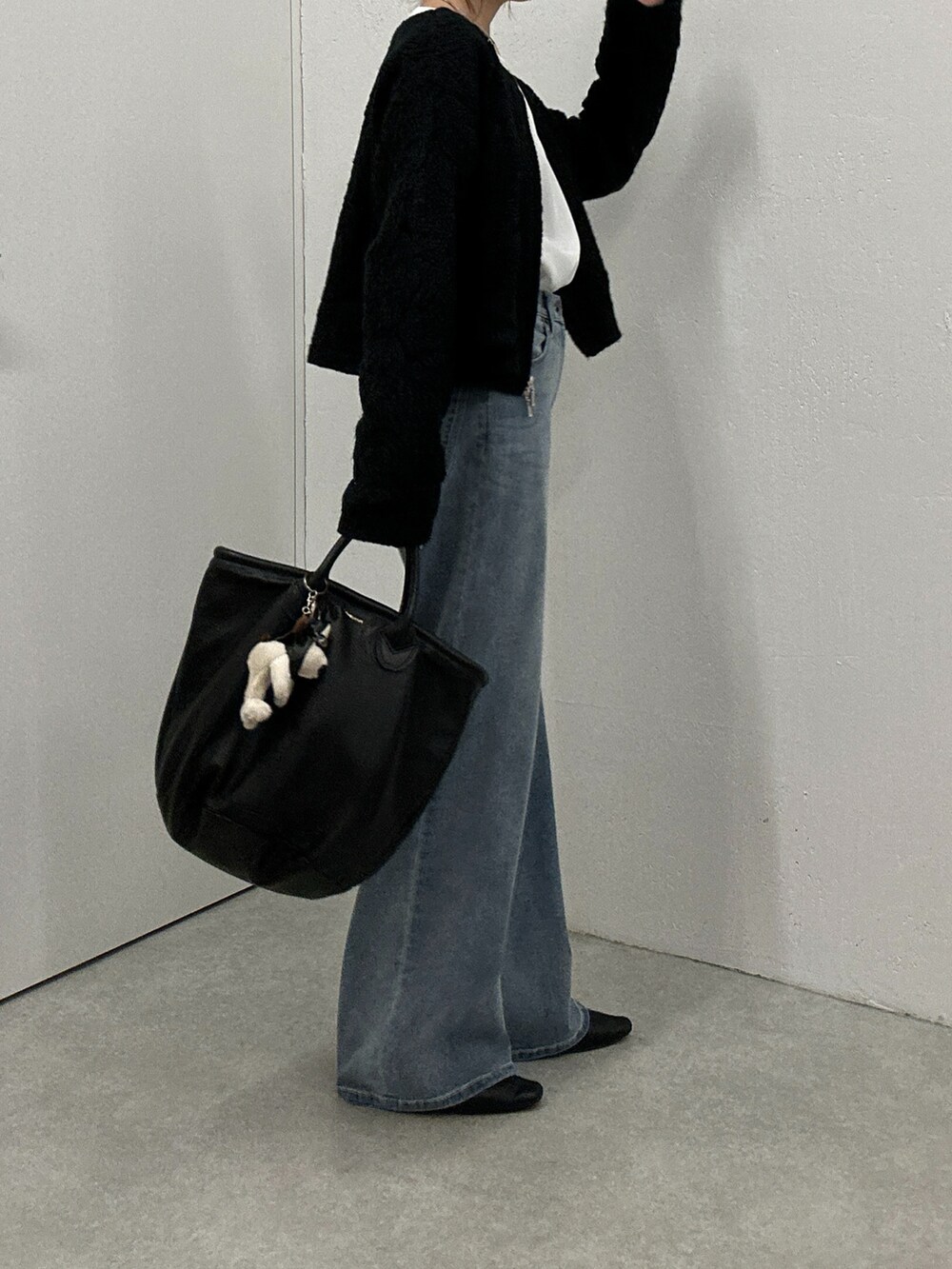 ブルー系のデニムパンツ、ブラック系のカーディガン/ボレロ、ホワイト系のシャツ/ブラウスを着用したレディースの秋コーディネートの3枚目の写真