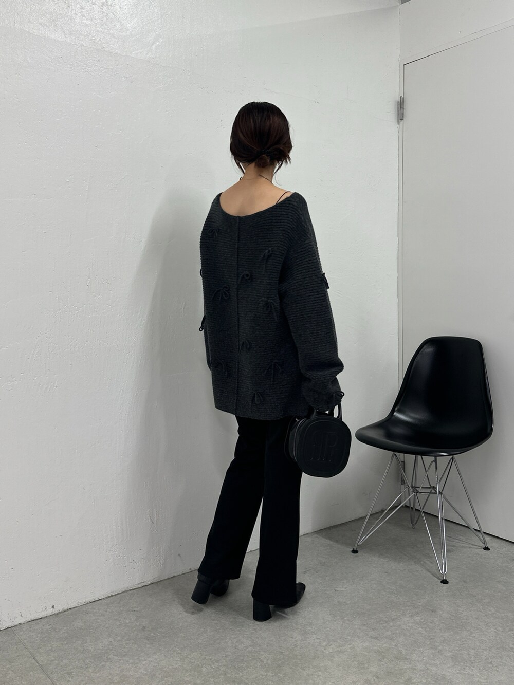 グレー系のニット/セーター、ブラック系のその他パンツ、ブラック系のハンドバッグを着用したレディースの秋コーディネートの4枚目の写真