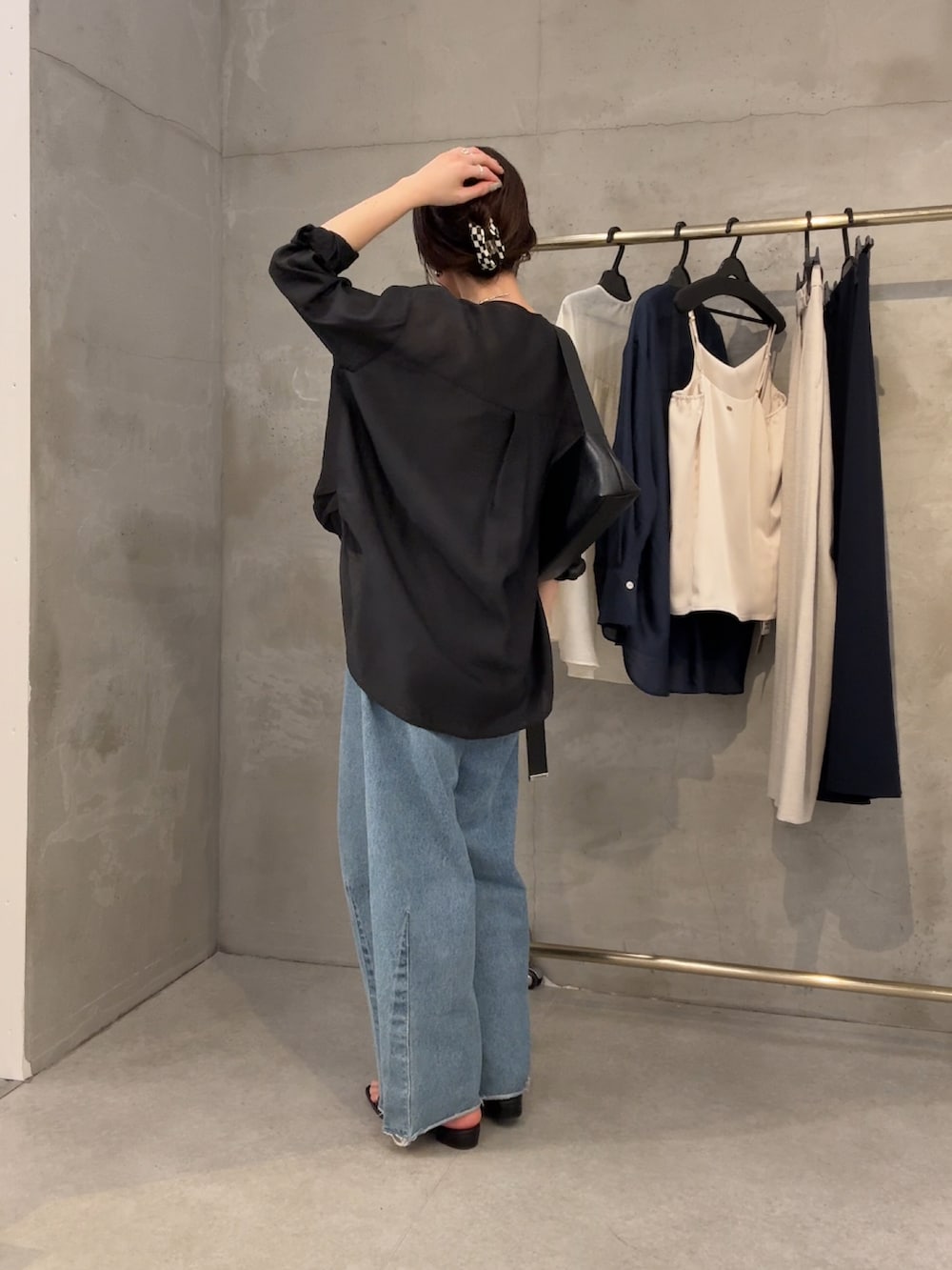 ブラック系のシャツ/ブラウス、ブルー系のデニムパンツ、ブラック系のバッグを着用したレディースの冬コーディネートの2枚目の写真
