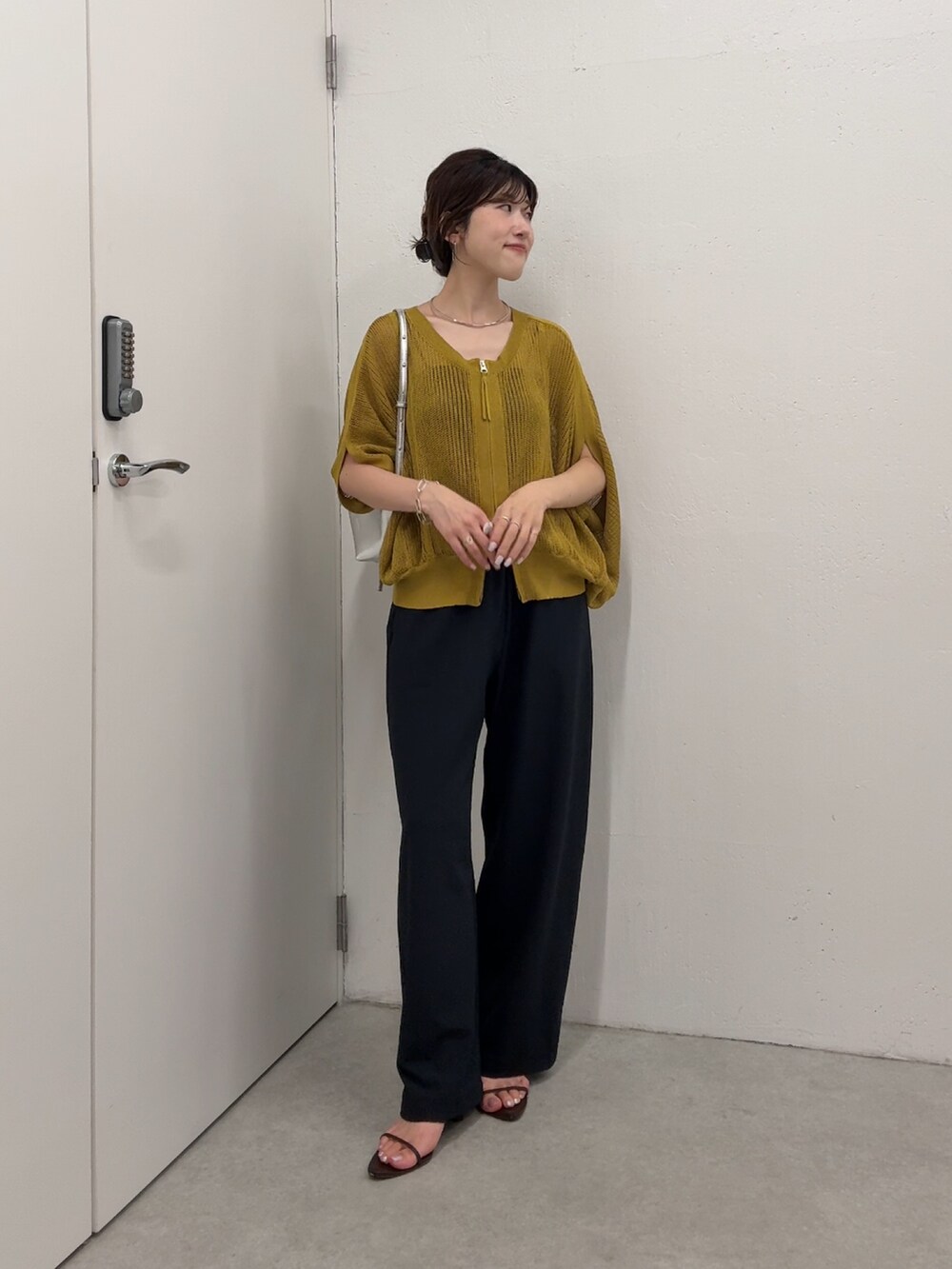 イエロー系のカーディガン/ボレロ、ブラック系のその他パンツ、シルバー系のショルダーバッグを着用したレディースの夏コーディネートの2枚目の写真
