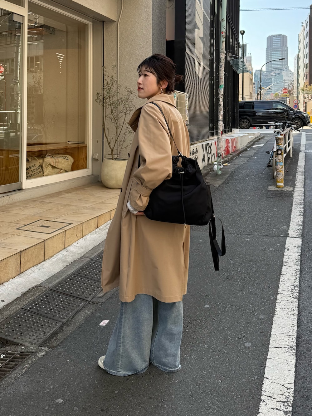 ブラック系のバックパック/リュック、ベージュ系のその他アウター、ブルー系のデニムパンツを着用したレディースの冬コーディネートの2枚目の写真