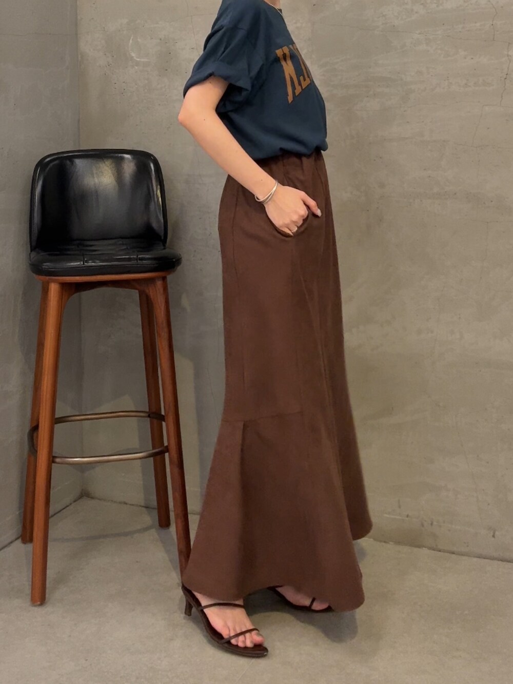 ブルー系のTシャツ/カットソー、ブラウン系のスカート、ブラウン系のショルダーバッグを着用したレディースの夏コーディネートの2枚目の写真