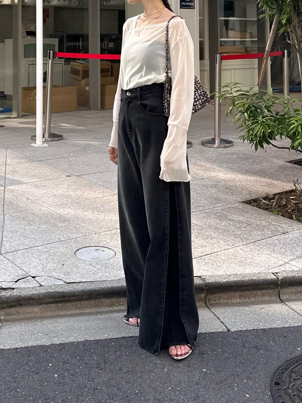 ホワイト系のTシャツ/カットソー、ブラック系のデニムパンツ、ブラック系のバッグを着用したレディースの夏コーディネートの2枚目の写真