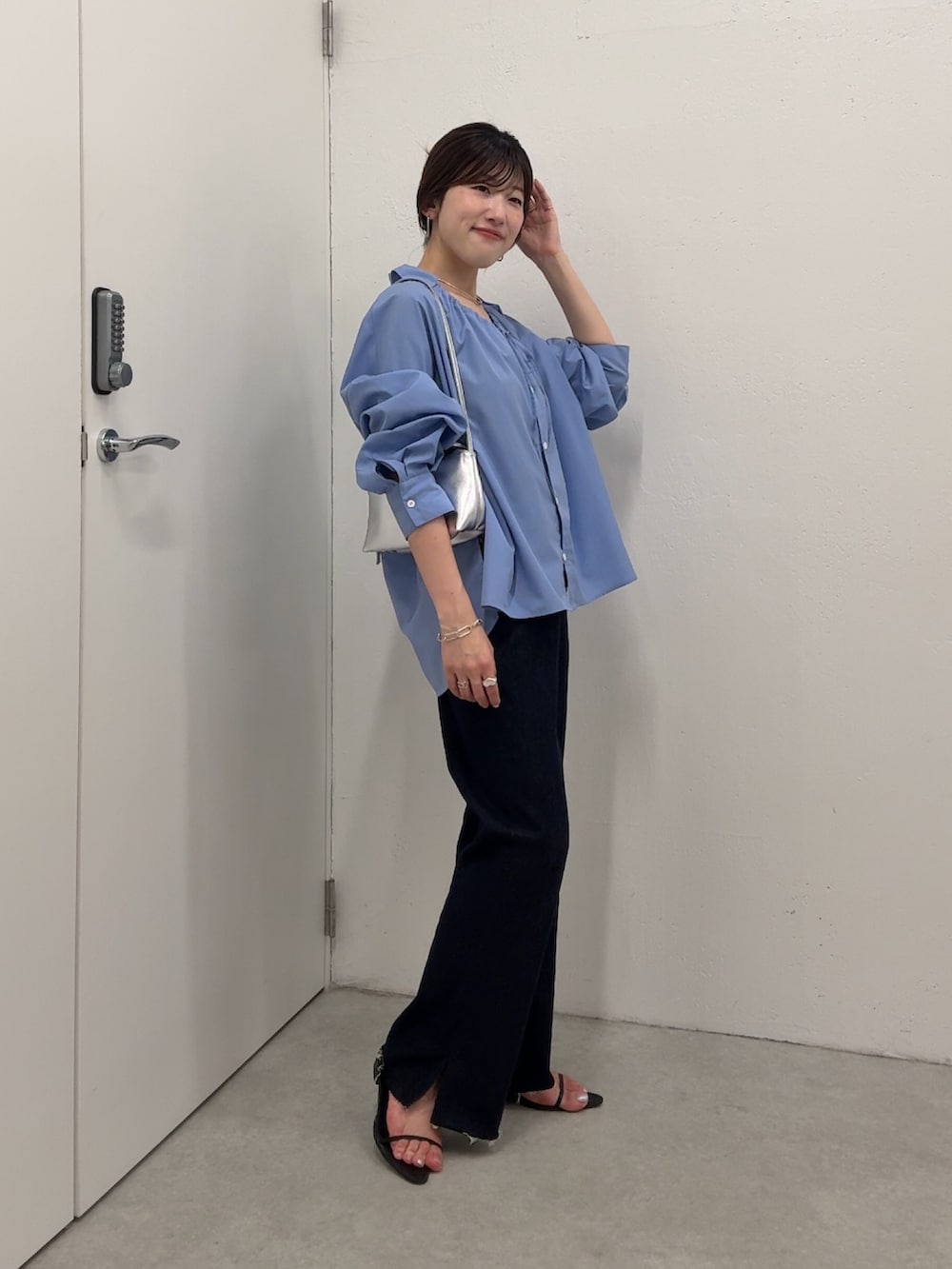 ブルー系のシャツ/ブラウス、ブルー系のデニムパンツ、シルバー系のショルダーバッグを着用したレディースの夏コーディネートの3枚目の写真