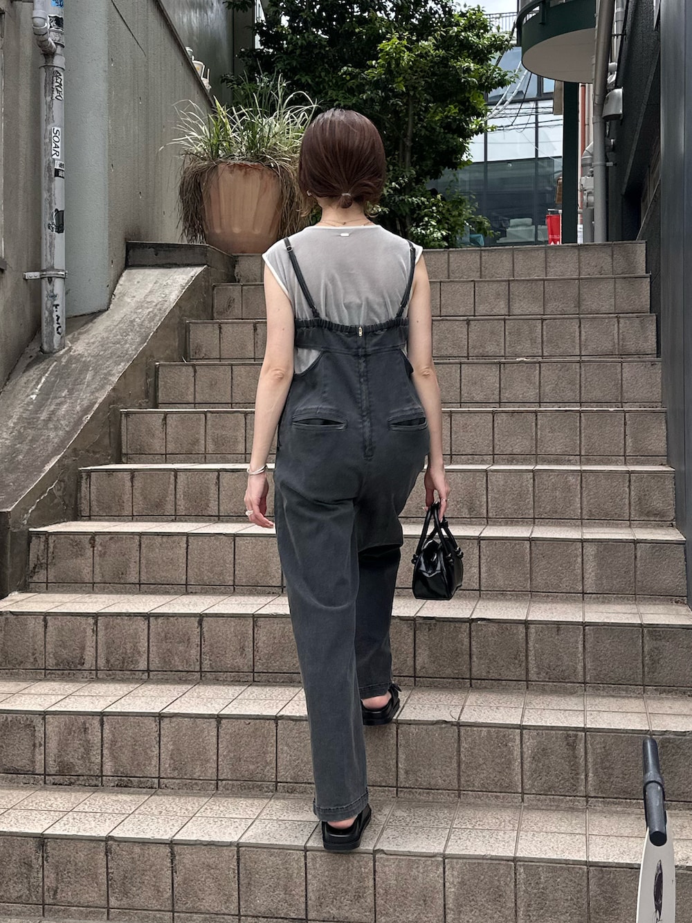 ブラック系のつなぎ/オールインワン、ブラック系のバッグ、グレー系のTシャツ/カットソーを着用したレディースの春コーディネートの4枚目の写真