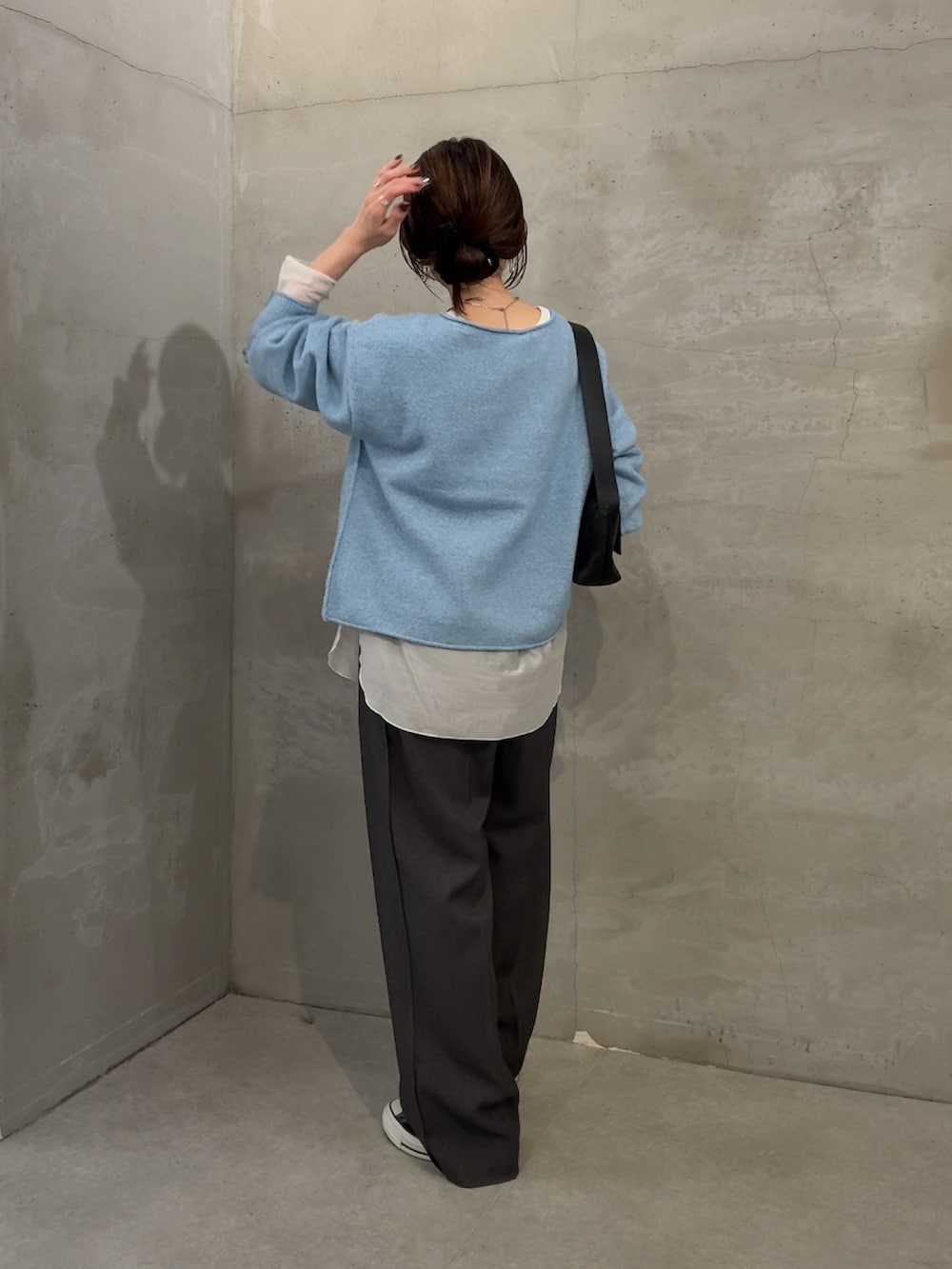 ブルー系のニット/セーター、ホワイト系のTシャツ/カットソー、グレー系のスラックスを着用したレディースの秋コーディネートの2枚目の写真