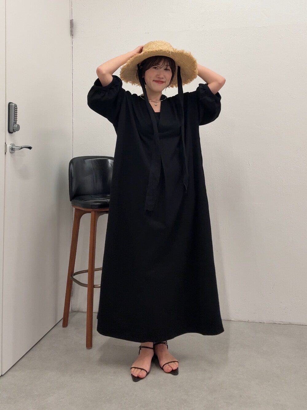 ブラック系のワンピース、ブラック系のトートバッグを着用したレディースの春コーディネートの5枚目の写真