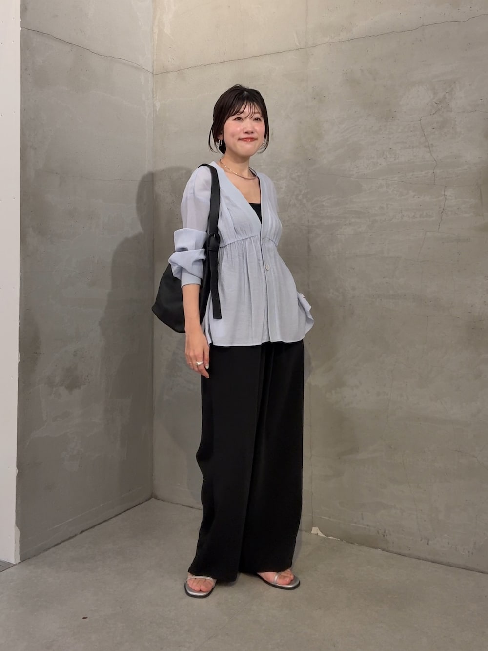 ブルー系のシャツ/ブラウス、ブラック系のスラックスを着用したレディースの冬コーディネートの3枚目の写真